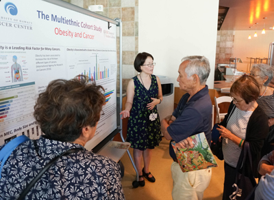 woman pointing to presentation board surrounded by people